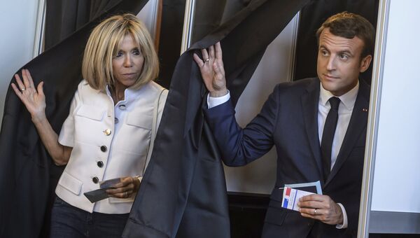 Президент Франции Эммануэль Макрон и его жена Брижит Макрон покидают избирательный участок. 11 июня 2017