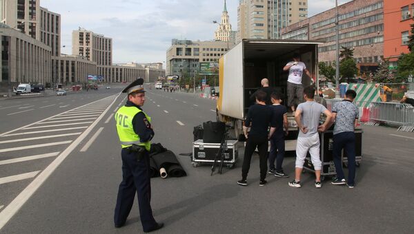Рабочие загружают оборудование в автомобиль после окончания санкционированной акции на проспекте Сахарова в Москве. 12 июня 2017