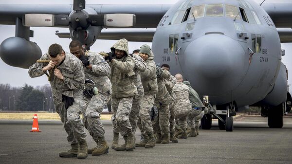 Американские солдаты тянут военно-транспортный самолет C-130H Hercules. Архивное фото