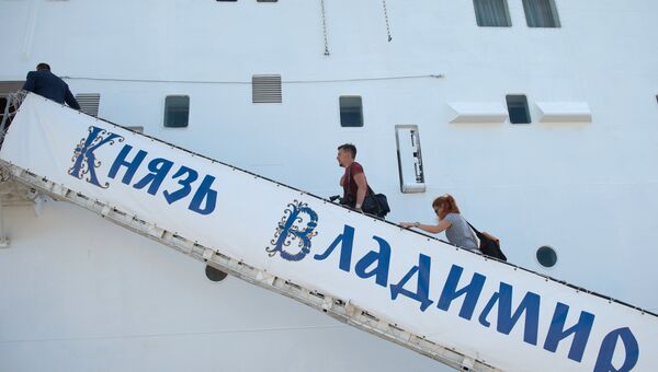 Пассажиры поднимаются на борт круизного лайнера Князь Владимир в порту города Сочи