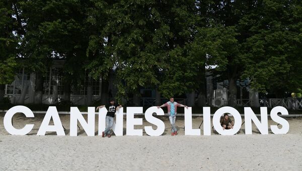 Посетители фестиваля-показа Каннские львы в Москве фотографируются на фоне инсталляции Cannes Lions