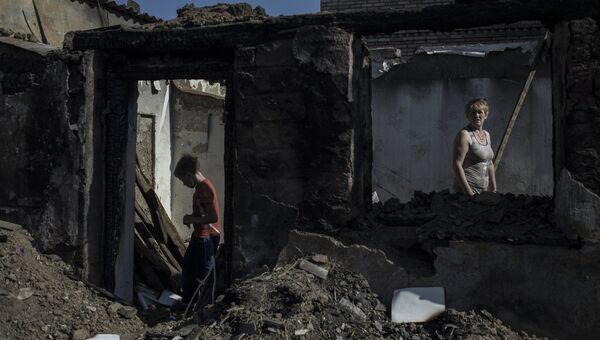 Жители в пострадавшем во время обстрела поселке в ДНР. Архивное фото