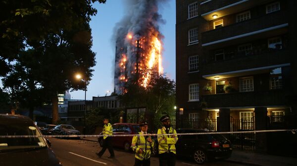 Сотрудники полиции на месте пожара в многоэтажном доме Grenfell Tower в Лондоне. 14 июня 2017