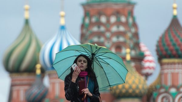 Девушка на Красной площади в Москве во время дождя. Архивное фото
