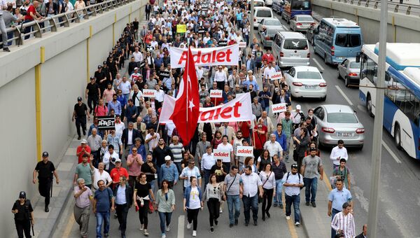 Демонстранты держат плакаты с надписью Справедливость во время марша протеста в Анкаре. 15 июня 2017