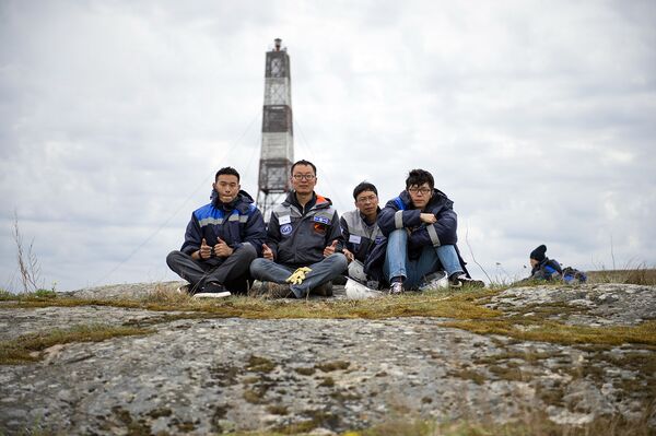 Команда китайских участников на фоне маяке, остров Соммерс