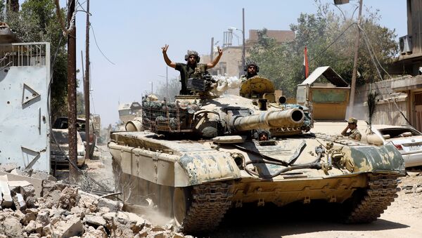 Иракский военный танк продвигается к позиции боевиков ИГ* в Старом Городе на западе Мосула. 18 июня 2017