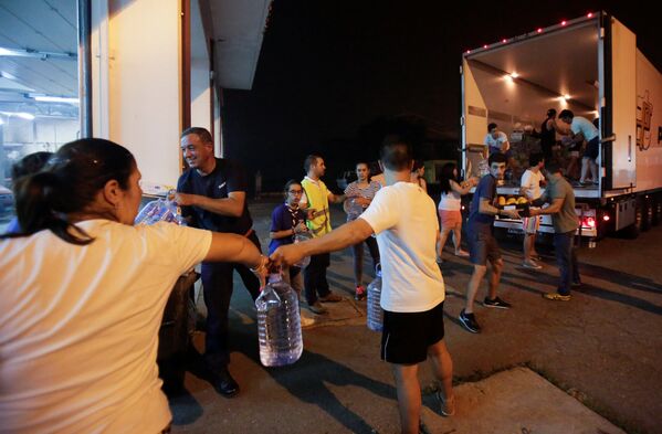 Волонтеры разгружают продовольствие на пожарной станции в Педрогао Гранде, Португалия