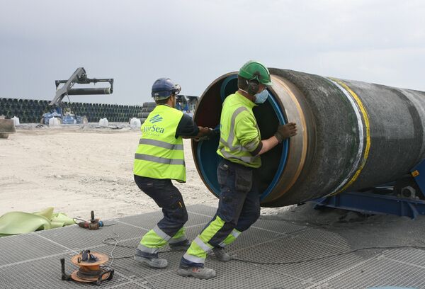 Рабочие подготовливают трубы для строящегося газопровода Северный поток к погрузке на судно доставки Рабочие подготовливают трубы для строящегося газопровода Северный поток к погрузке на судно доставки