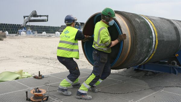 Рабочие подготовливают трубы для строящегося газопровода Северный поток  к погрузке на судно доставки