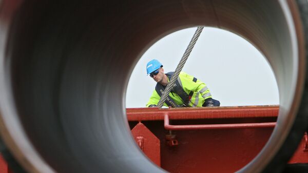  Рабочие подготовливают трубы для строящегося газопровода Северный поток к погрузке на судно доставки 