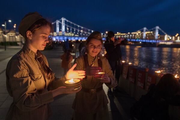 Участники патриотической акции Линия памяти зажигают свечи на Крымской набережной вдоль Москвы-реки в память о погибших в Великой Отечественной войне