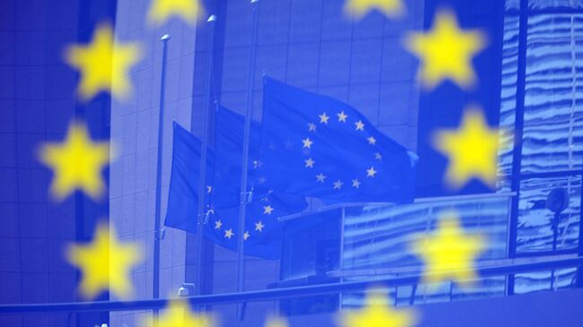 Флаги в отражении на стенде с эмблемой ЕС. Архивное фото