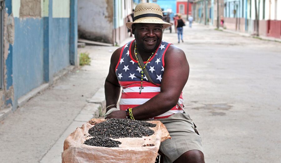 Продавец семечек в майке с изображением американского флага в районе Старая Гавана, Куба