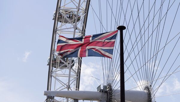 Флаг на фоне аттракциона Лондонский глаз в Лондоне. Архивное фото