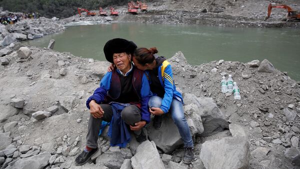 Родственники жертв пострадавших от оползня в деревне Синьмо округа Мао провинции Сычуань, Китай. 26 июня 2017
