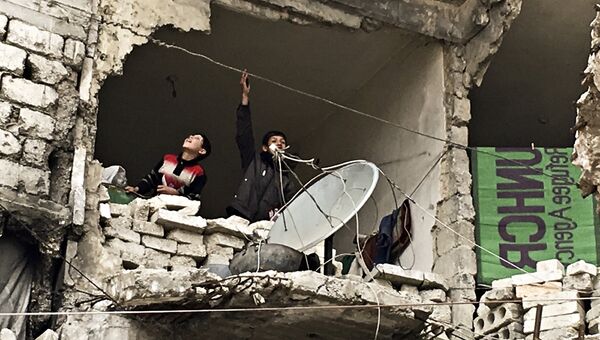 Жители в разрушенном доме города Нубель на севере провинции Алеппо. Сирия, 11.02.2016