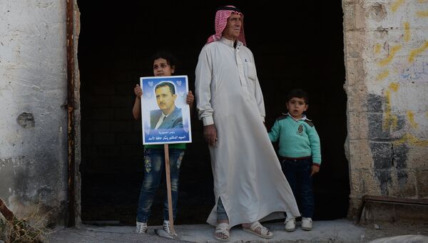 Жители населенного пункта Каукаб в Сирии с портретом Башара Асада. Архивное фото