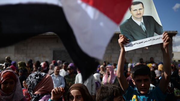 Жители населенного пункта Каукаб в Сирии с портретом Башара Асада. Архивное фото
