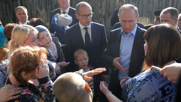 Владимир Путин общается с жителями во время посещения аварийного жилья семьи Анастасии Вотинцевой в Ижевске. 27 июня 2017