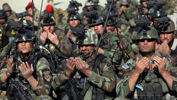 Служащие сил безопасности Афганистана совершают молитву во время церемонии  происходящей к востоку от Кабула, после того как НАТО завершила свою 13-летнюю миссию в Афганистане