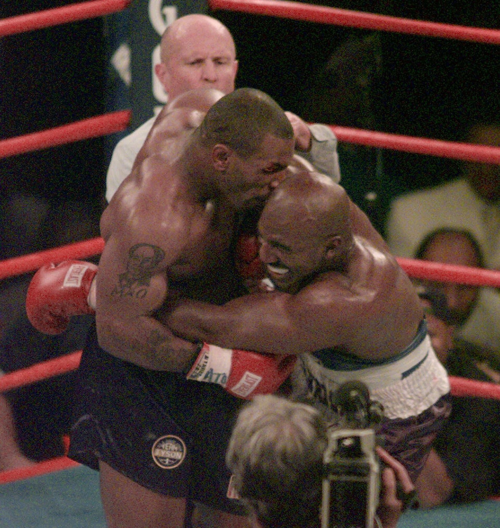 Майк Тайсон, кусает ухо Эвандера Холифилда в третьем раунде боксерского поединка WBA в супертяжелом весе в Лас-Вегасе. 28 июня 1997  - РИА Новости, 1920, 27.06.2022