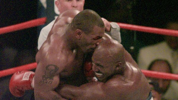 Майк Тайсон, кусает ухо Эвандера Холифилда в третьем раунде боксерского поединка WBA в супертяжелом весе в Лас-Вегасе. 28 июня 1997