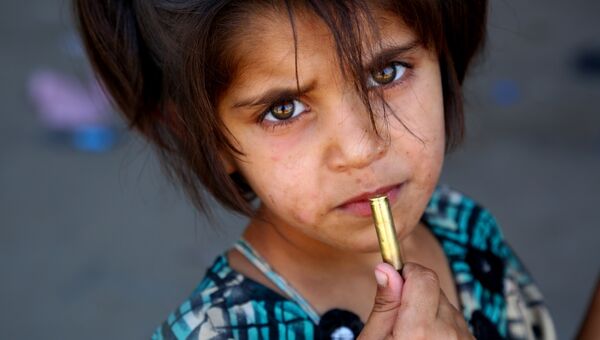 Сирийская девочка с патроном в руке в деревне Джазра в пригороде Ракки. Архивное фото