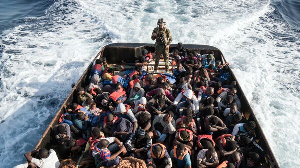 Сотрудник Ливийской береговой охраны во время спасения нелегальных мигрантов, пытающихся добраться до Европы, недалеко от Эз-Завия