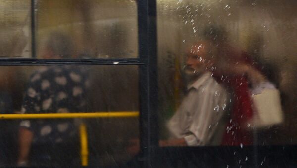 Пассажиры в автобусе во время дождя в Москве