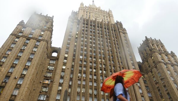 Девушка с зонтом во время дождя у здания МИД РФ в Москве