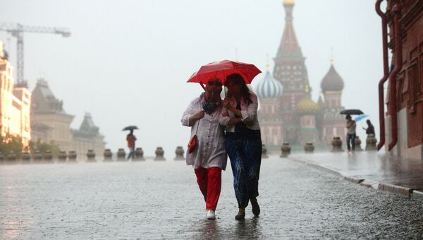 Прохожие под зонтом во время дождя на Красной площади в Москве. Архивное фото