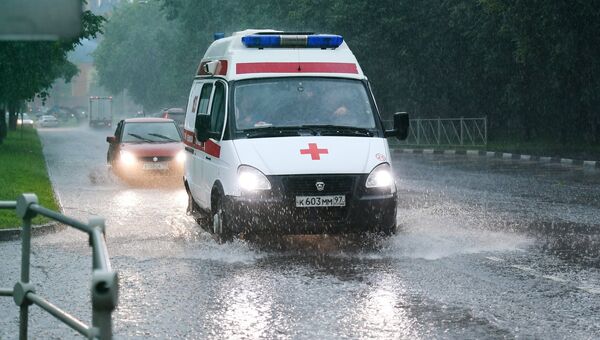 Автомобиль скорой помощи во время дождя в Москве. 30 июня 2017