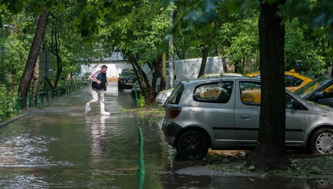 Потоки воды в одном из дворов после дождя в Москве