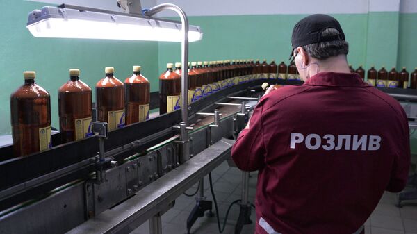 Сотрудники у линии розлива пива в полиэтиленовые бутылки в цехе розлива пива 