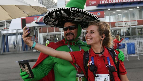 Болельщик сборной Мексики фотографируется с волонтером