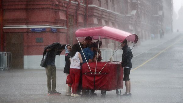 Прохожие во время дождя на Красной площади в Москве