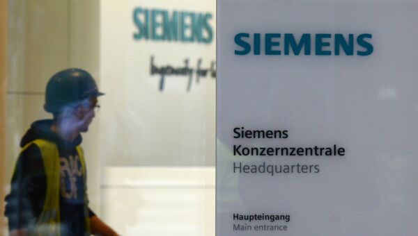 Рабочий у входа в штаб-квартиру компании Siemens в Мюнхене. Архивное фото