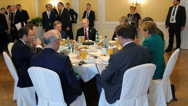 Президент РФ Владимир Путин во время совместного с канцлером Германии Ангелой Меркель и президентом Франции Эммануэлем Макроном завтрака на полях саммита G20 в Гамбурге