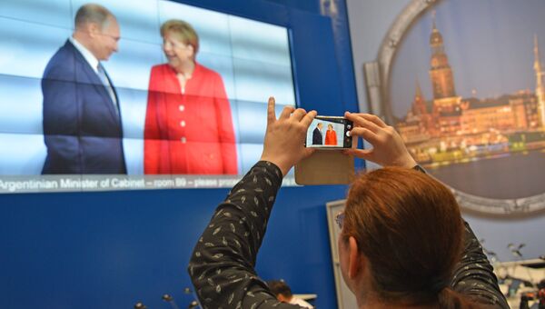 Журналисты в международном пресс-центре во время трансляции официальной встречи президента РФ Владимира Путина канцлером Германии Ангелой Меркель