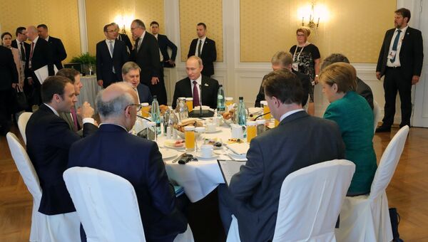 Президент РФ Владимир Путин во время совместного с канцлером Германии Ангелой Меркель и президентом Франции Эммануэлем Макроном завтрака на полях саммита лидеров Группы двадцати G20 в Гамбурге. 8 июля 201