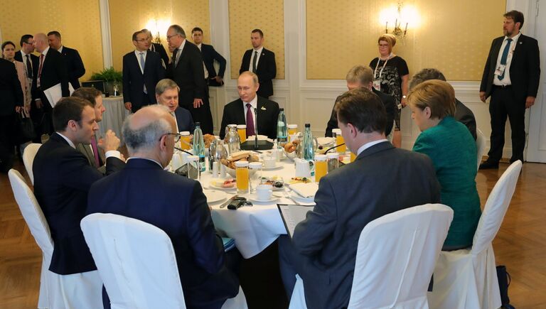 Президент РФ Владимир Путин во время совместного с канцлером Германии Ангелой Меркель и президентом Франции Эммануэлем Макроном завтрака на полях саммита лидеров Группы двадцати G20 в Гамбурге. 8 июля 201
