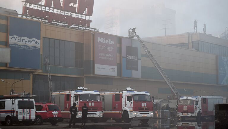 Сотрудники полиции и противопожарной службы во время тушения пожара в здании торгового центра РИО на Дмитровском шоссе в Москве
