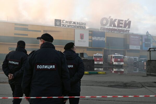 Сотрудники правоохранительных органов во время тушения пожара в здании торгового центра РИО на Дмитровском шоссе в Москве
