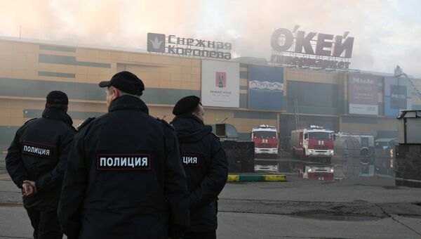 Сотрудники правоохранительных органов во время тушения пожара в здании торгового центра РИО на Дмитровском шоссе в Москве