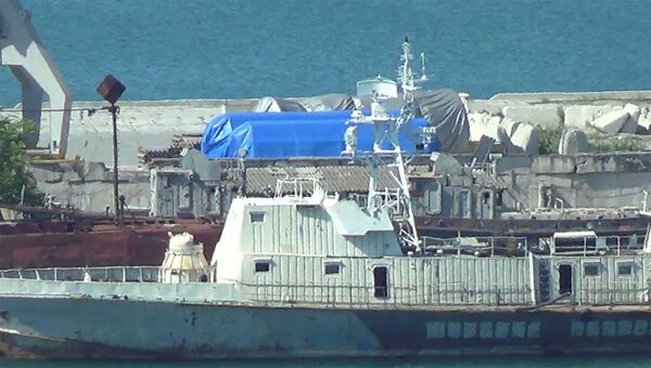 Снимок из видеоматериала, где видны синие брезенты, покрывающие оборудование в порту Феодосия, Крым. 11 июля 2017
