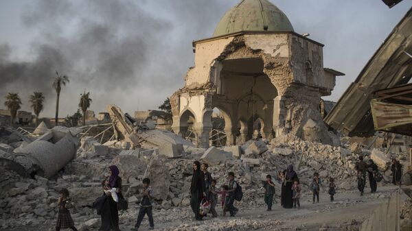 Местные жители прохят мимо разрушенной мечети в Мосуле, Ирак
