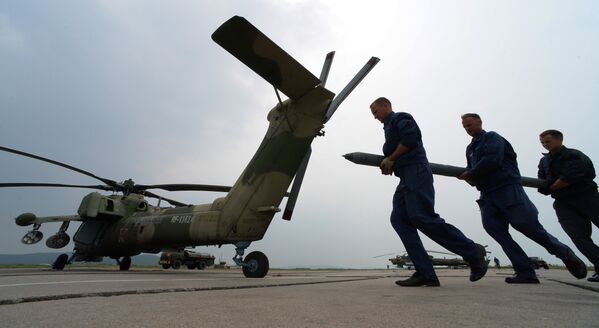 Авиационные техники готовят вертолет Ми-28 к вылету во время учений отдельного вертолетного полка на аэродроме Черниговка в Приморском крае