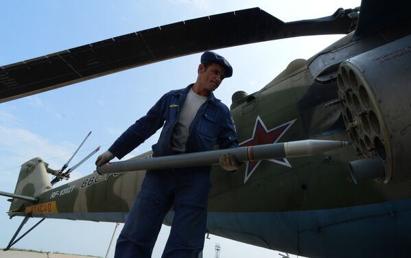 Авиационные техники готовят вертолет Ми-35 к вылету во время учений отдельного вертолетного полка на аэродроме Черниговка в Приморском крае