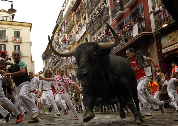 Гуляющие убегают от быка во время фестиваля Сен-Фермин в Памплоне
